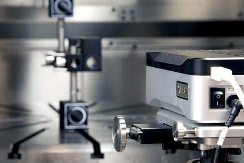 Interferómetro láser XL-80 y ópticas realizando un ensayo en una máquina